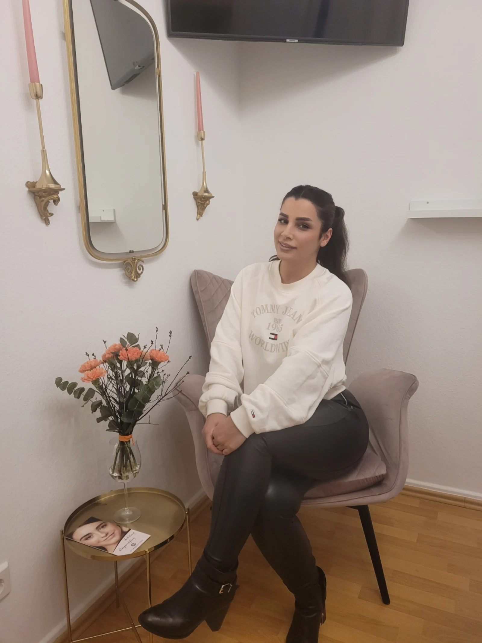 Warme Warteecke mit Blumen und goldenem Spiegel im Studio