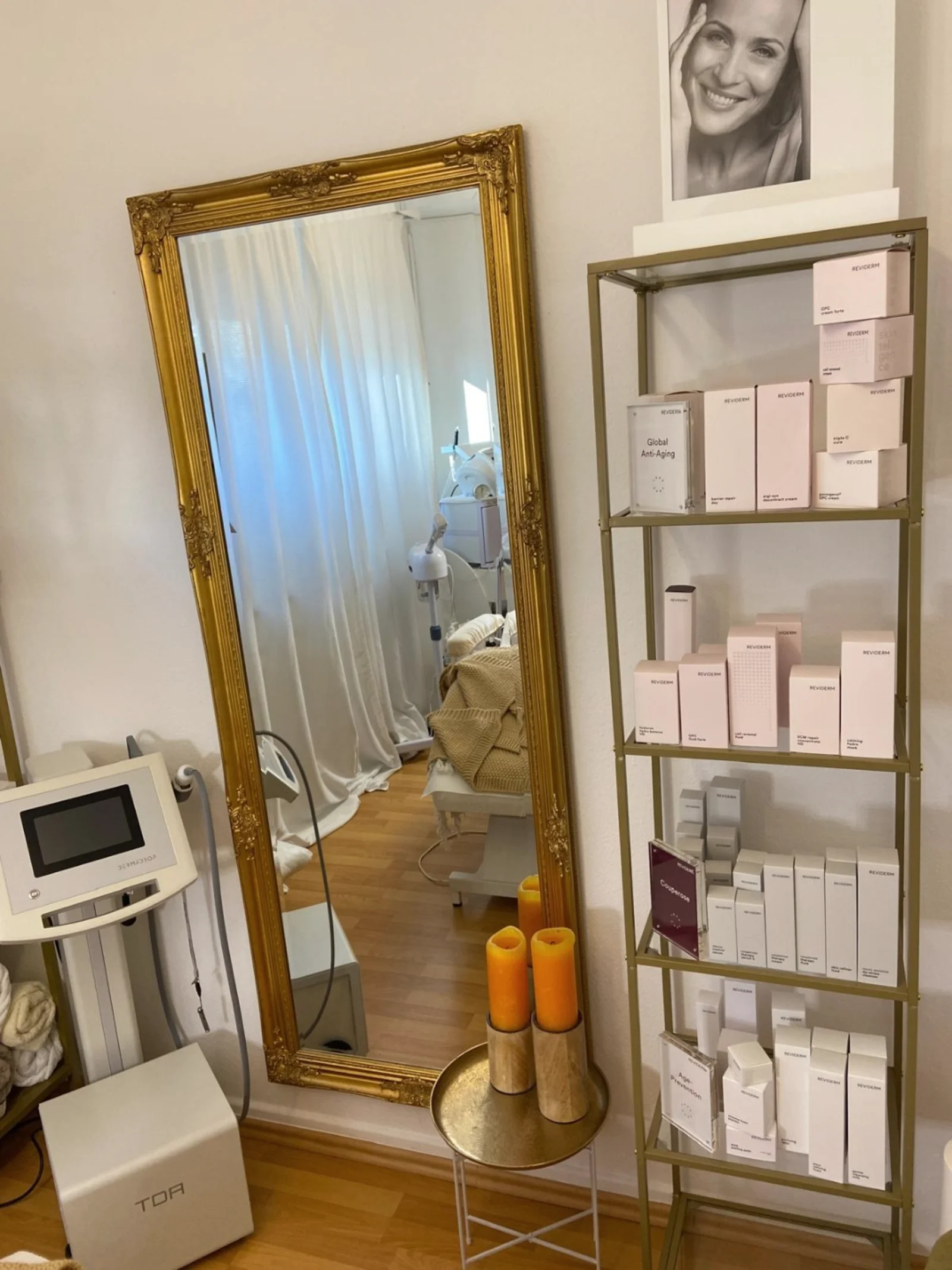 Goldener Wandspiegel und REVIDERM-Pflegeregal im Aesthetic Beauty Day Spa Kerpen